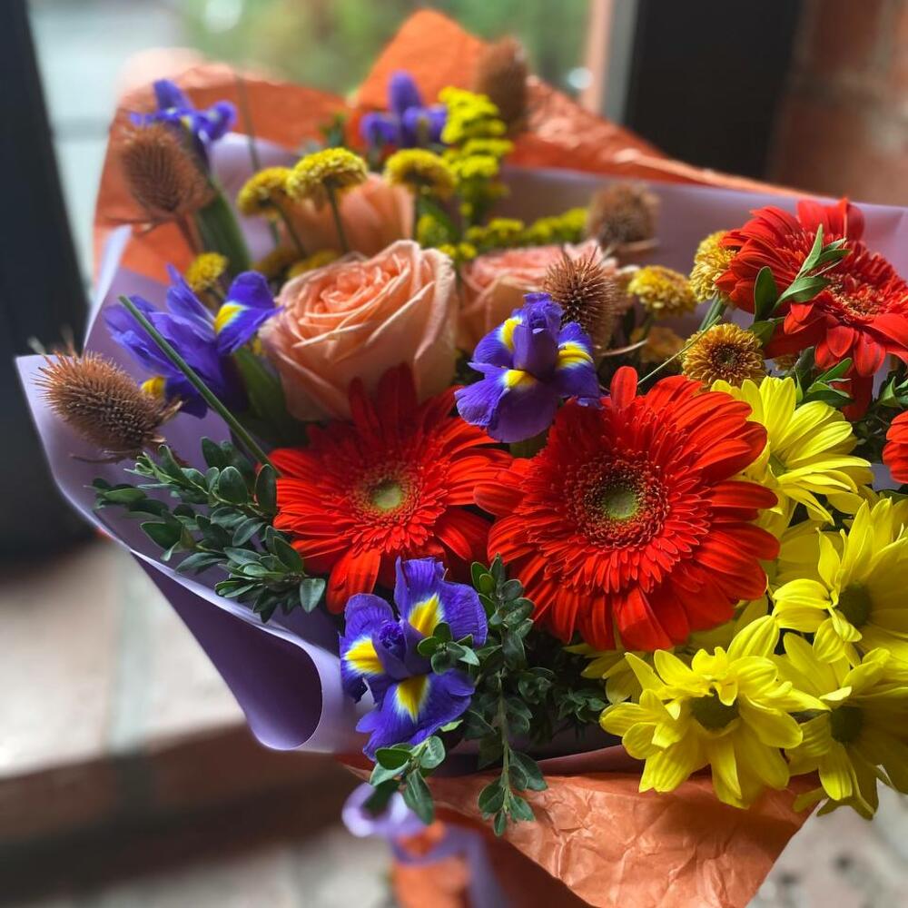 Букет из гербер, ирисов, кустовой хризантемы, пионовидных роз, самшита и эрингиума в стильной упаковке "Чистые краски осени"